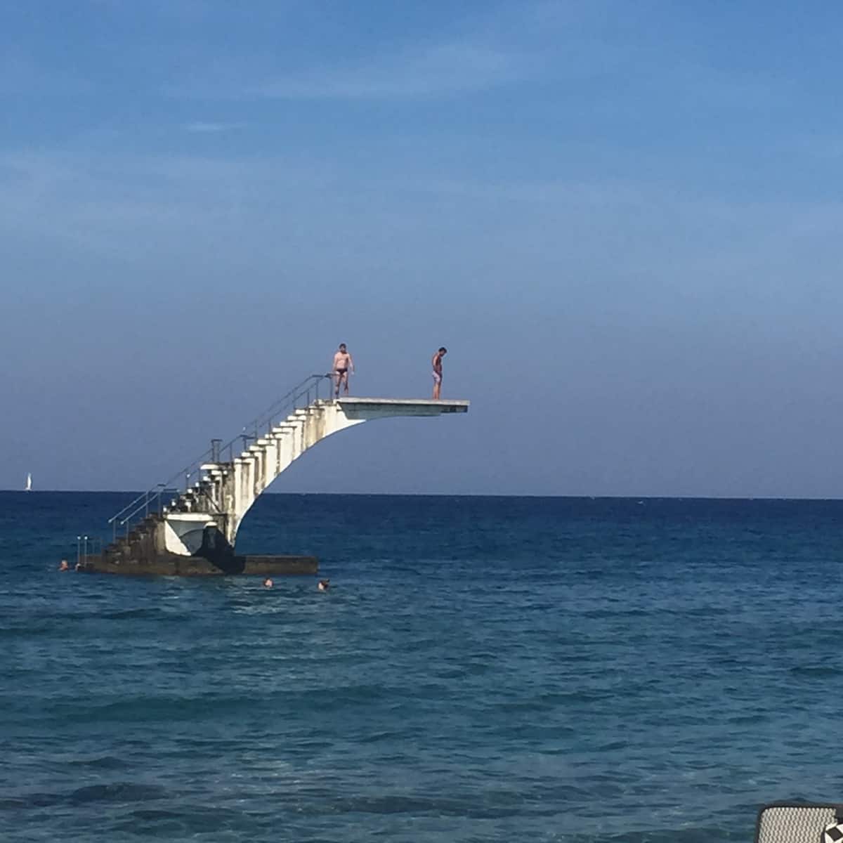 A white diving platform over deep blue open water